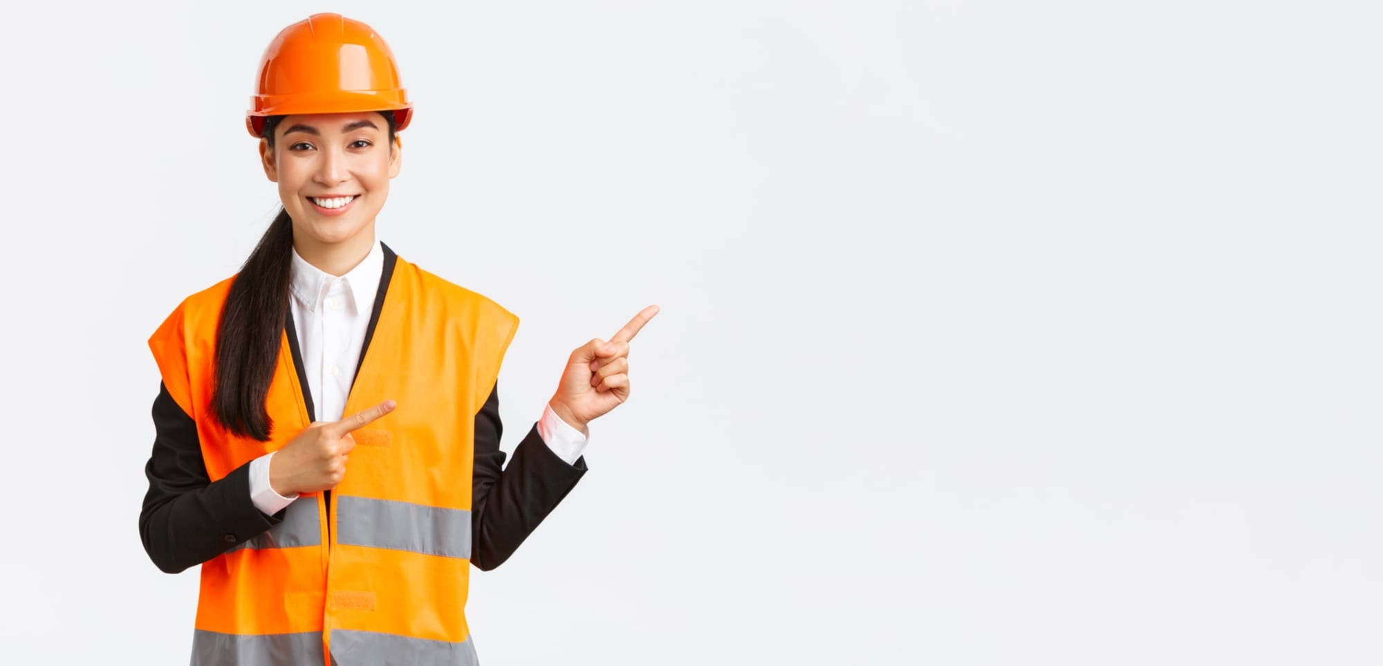 Woman in high vis with hard hat pointing to the right